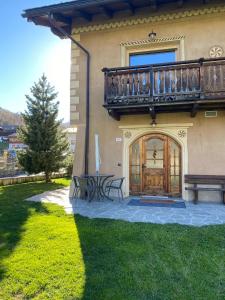 een huis met een balkon en een tafel en banken bij Baita Brozol in Livigno