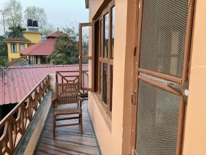 d'un balcon avec deux chaises et une fenêtre. dans l'établissement Sauraha Guest House, à Sauraha