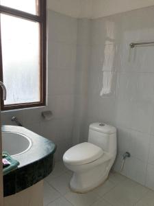 La salle de bains est pourvue de toilettes, d'un lavabo et d'une baignoire. dans l'établissement Sauraha Guest House, à Sauraha