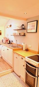 a kitchen with a sink and a stove at Appleyard Cottage - Yorkshire Dales in Hellifield