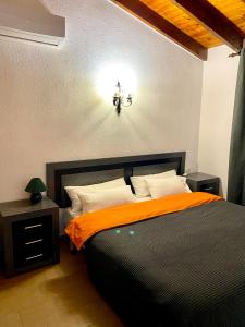 1 dormitorio con cama negra y manta naranja en Playa del Sol - Primera Línea, en Denia