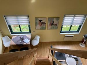 a room with a table and chairs and two windows at Kantor See-Chalets am Millstätter See in Rothenthurn