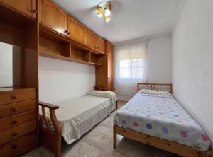 1 dormitorio con 2 camas y vestidor en Apartamento en El Puerto de Santa María, en El Puerto de Santa María