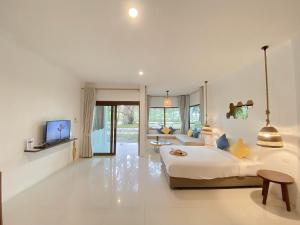 a bedroom with a large bed and a living room at Issara Beach Resort Beachfront in Sichon