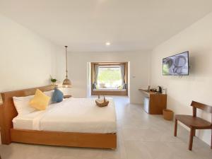 a bedroom with a bed and a table and a window at Issara Beach Resort Beachfront in Sichon