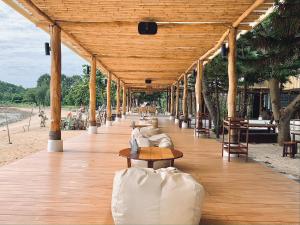 a wooden pavilion with a person sitting on a table at Issara Beach Resort Beachfront in Sichon