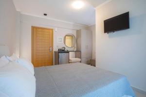 um quarto com uma cama e uma televisão na parede em Zisis Suites em Nydri