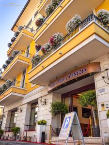 un bâtiment avec un panneau de stationnement devant lui dans l'établissement Hotel Villa Venezia, à Grado