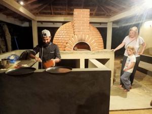a man and a woman standing next to a brick oven at Gal Oya Lake Club 