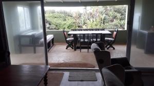 a living room with a table and chairs and a window at Porta Salutis in Port St Johns