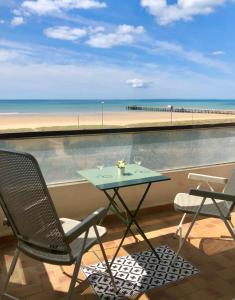 a table and chairs on a balcony with a view of the beach at Studio face à la mer in Saint-Jean-de-Monts