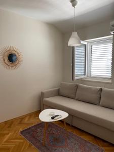 a living room with a couch and a table at First line Apartment Petrovac in Petrovac na Moru +1 photo