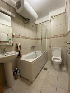 a bathroom with a toilet and a tub and a sink at First line Apartment Petrovac in Petrovac na Moru