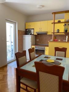 a kitchen with a dining room table and chairs at First line Apartment Petrovac in Petrovac na Moru