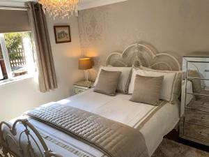 1 dormitorio con 1 cama blanca grande y cabecero grande en Eve’s Contemporary Cabin in Kent Woodland Setting, en Kent