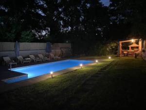 a swimming pool with lights in a yard at night at Duos Rios in Mostar