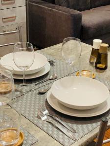 een tafel met borden en wijnglazen erop bij Cosy New Apartment in Portello Certosa in Milaan
