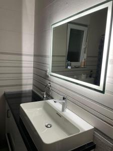 baño con lavabo y espejo grande en Duos Rios, en Mostar