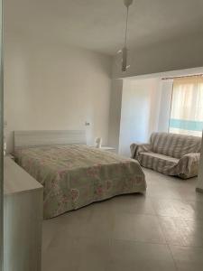 1 dormitorio con 1 cama y 1 sofá en Casa vacanze La Maddalena, en La Maddalena