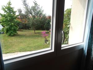 una ventana con vistas a un patio con una maceta de flores en Petite chambre particulière, en La Force