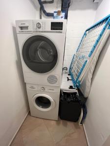 a washer and dryer in a corner of a room at Dock 8 Strande: 50m bis zum Strand u. der Promenade in Strande