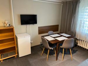 a room with a table and chairs and a television at Pokoje gościnne in Dźwirzyno