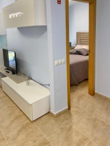 1 dormitorio con 1 cama y TV en un armario en Classy Apartments, en Denia