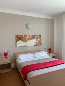 1 dormitorio con 1 cama con una pintura en la pared en Residence Alba, en Riccione