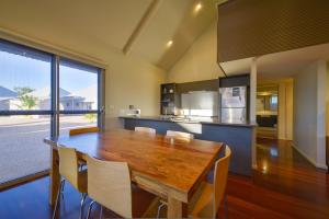 a kitchen with a table, chairs and a refrigerator at Exmouth Escape Resort in Exmouth