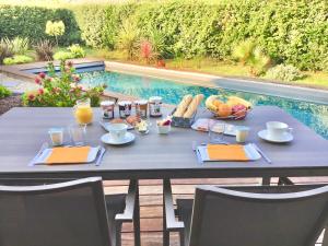 a table with food and drinks and a bowl of fruit at La villa du golf - chambre d hôtes in Gujan-Mestras