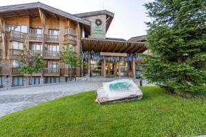 un bâtiment avec un matelas dans l'herbe devant lui dans l'établissement Pirin Golf&Spa Apartment 42, à Razlog