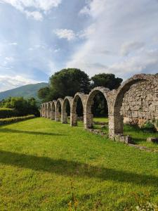 un viejo puente de piedra en un campo de hierba en B&B Gocciaverde en Rocchetta a Volturno