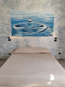 a bed in a bedroom with a painting on the wall at La Maison di Luca in Verona