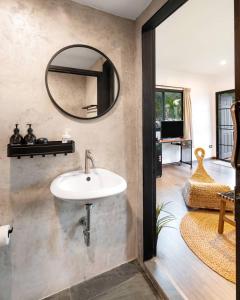 a bathroom with a sink and a mirror on the wall at Naramountainkhaoyai 04 in Ban Tha Chang