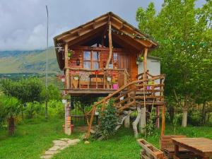 a tree house with a deck and a table at Life on the farm in Nepravishtë