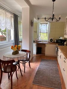 a kitchen with a table and some chairs and a table at Tulipán Villa Panzió in Szolnok