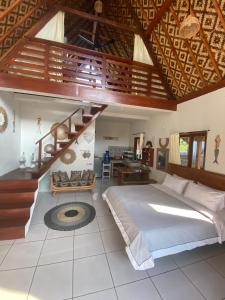 a bedroom with a large bed and a staircase at Hideaway Batukaras in Pangandaran