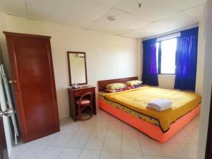 une chambre avec un lit, un miroir et une fenêtre dans l'établissement 311 Pangkor Coral Bay Homestay, à Kampong Pasir Bogak