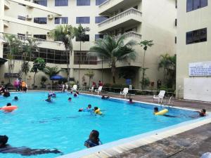 un groupe de personnes nageant dans une piscine dans l'établissement 311 Pangkor Coral Bay Homestay, à Kampong Pasir Bogak