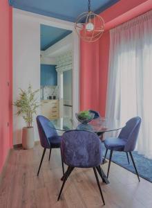 a dining room with a glass table and blue chairs at HOME OF THE SOUL in Ioannina