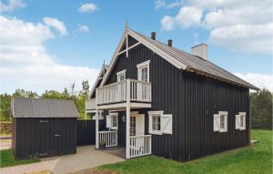 una casa negra con techo de gambrel y un garaje en Nice Home In Gjern With Wifi, en Gjern