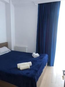 ein Schlafzimmer mit einem blauen Bett und Handtüchern darauf in der Unterkunft Blue Apartment in Gonio
