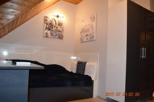 Zimmer mit einem Bett und Bildern an der Wand in der Unterkunft Villa Éden in Siófok
