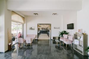 een kamer met stoelen, een tafel en een tv bij Zephyros Hotel in Kos-stad