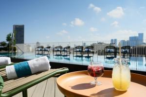 een tafel met twee drankjes op het balkon bij Alberto by Isrotel Design in Tel Aviv