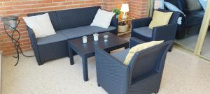 un patio con 2 sedie, un divano e un tavolo di Principado Marina Benidorm Playa Poniente a Benidorm