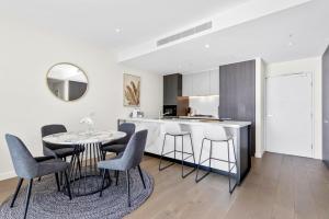 cocina y comedor con mesa y sillas en Macquarie Park Executive 2 Bedroom en Sídney