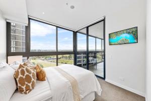 a bedroom with a white bed and large windows at Macquarie Park Executive 2 Bedroom in Sydney