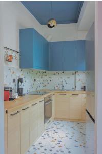 a kitchen with blue cabinets and a tile floor at HOME OF THE SOUL in Ioannina