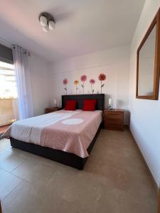 a bedroom with a large bed with red pillows at Casa Felicitas in Miami Platja